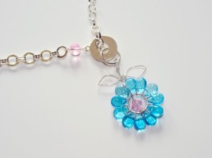 Aqua flower petals surround pink center and hang from 17" fancy chain.